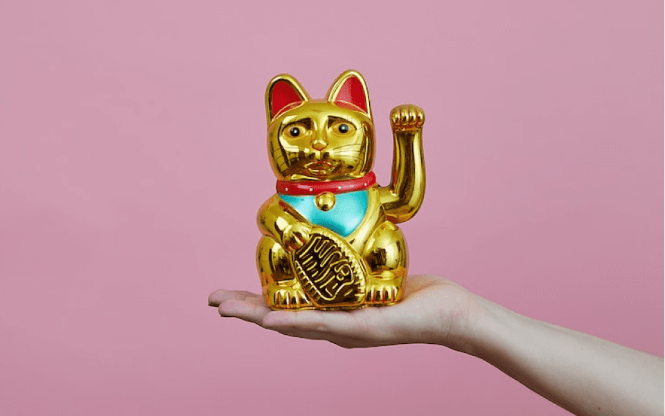 写真:金色の招き猫を手に乗せています