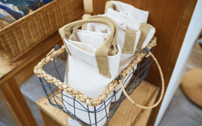 写真:工房尾道帆布のオリジナルトートが籠に並べられています