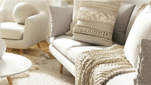 写真：白とベージュを基準とした家具が配置されてる部屋写真のソファーとクッションが切り取られています。